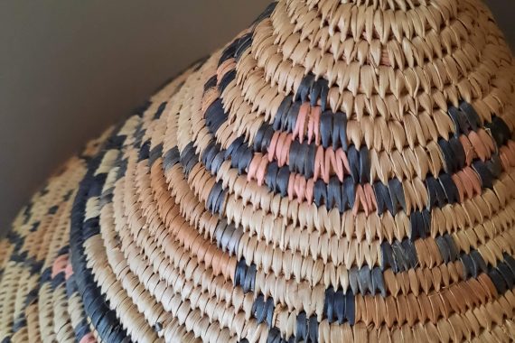 detail of handwoven Zulu beer storage basket from South Africa, patterned in shades of brown, orange & black